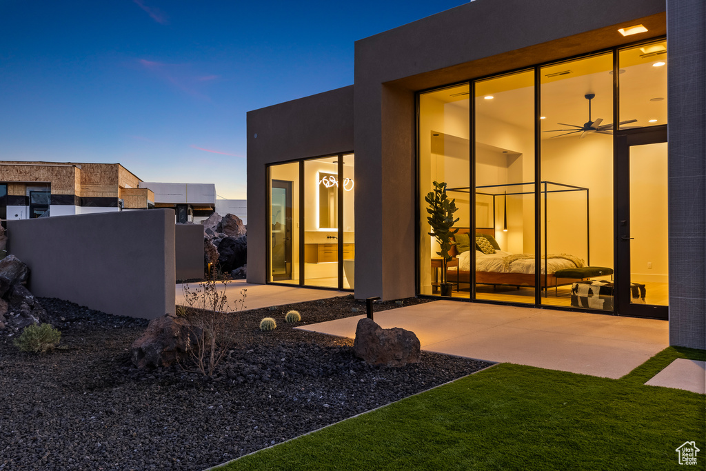 Back house at dusk with a patio area