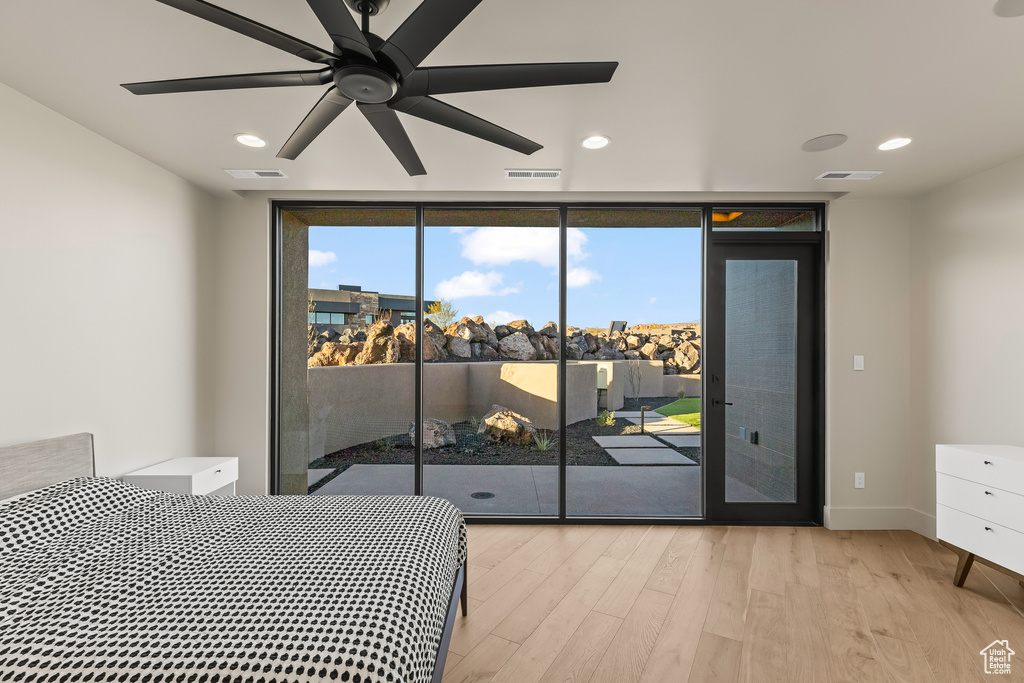 Bedroom with access to exterior, ceiling fan, light hardwood / wood-style floors, and a wall of windows