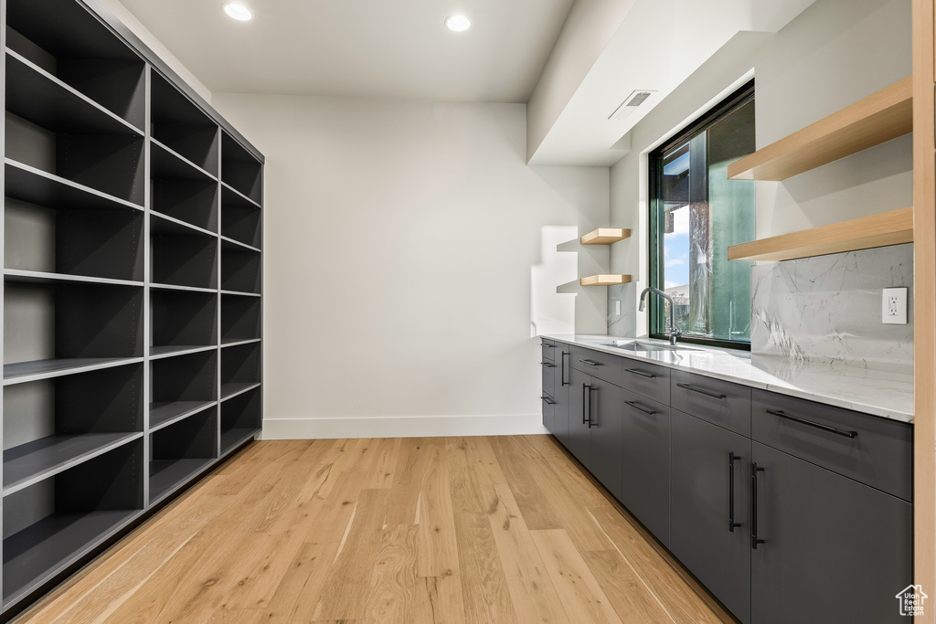 Kitchen featuring decorative backsplash, sink, and light hardwood / wood-style floors