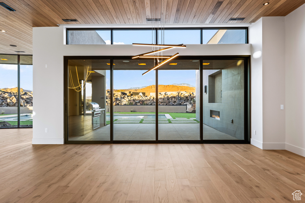 Spare room featuring a mountain view, hardwood / wood-style floors, a healthy amount of sunlight, and wood ceiling