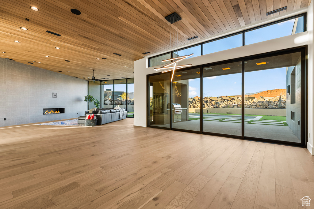 Interior space featuring a mountain view, ceiling fan, wooden ceiling, and light hardwood / wood-style floors