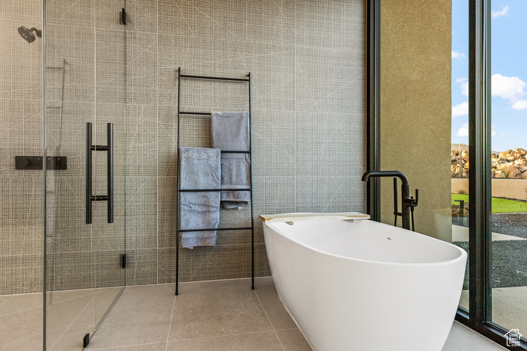 Bathroom with tile patterned floors and a bath