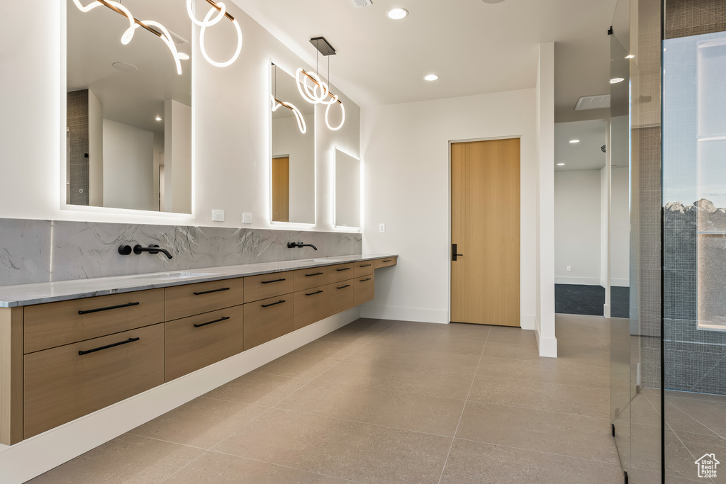 Bathroom with backsplash, tile patterned floors, and vanity