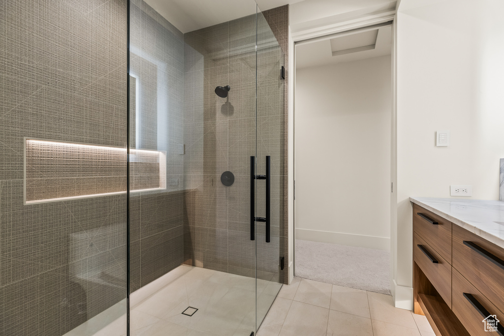 Bathroom featuring vanity, tile patterned floors, and a shower with shower door