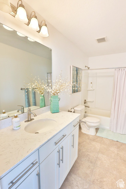 Full bathroom featuring vanity, shower / tub combo, and toilet