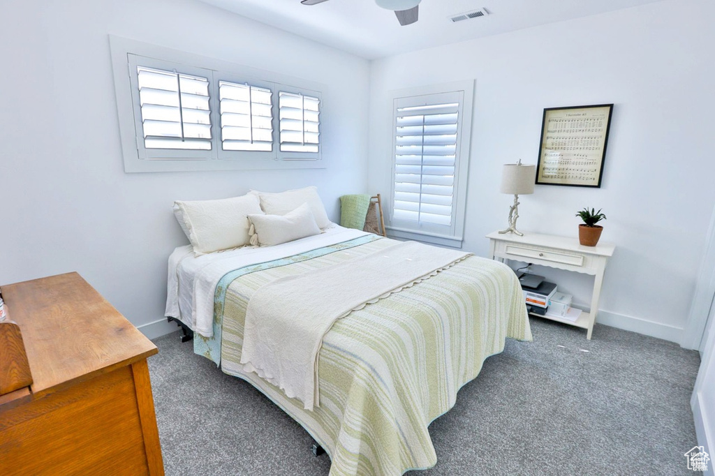Bedroom featuring ceiling fan and dark carpet