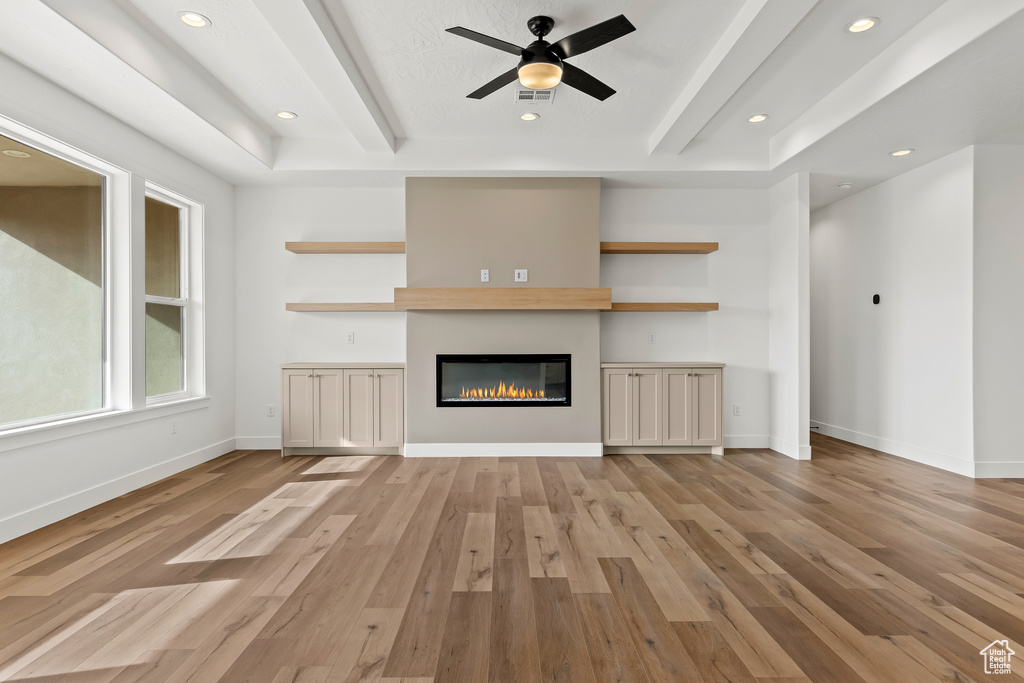 Unfurnished living room featuring ceiling fan and light wood-type flooring