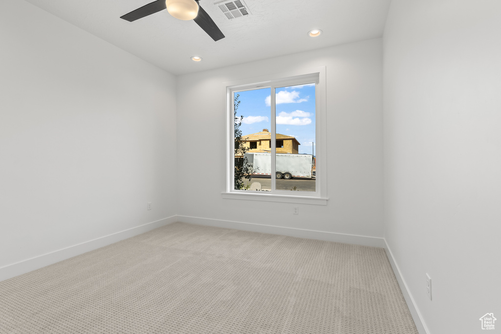 Carpeted spare room featuring ceiling fan