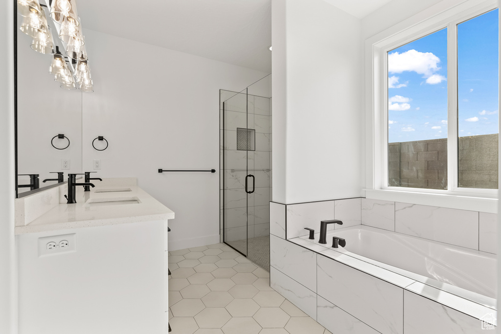 Bathroom with shower with separate bathtub, vanity, and tile patterned floors