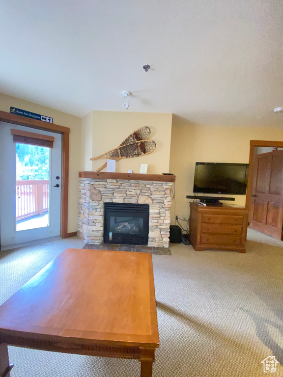 Living room with a stone fireplace and light carpet