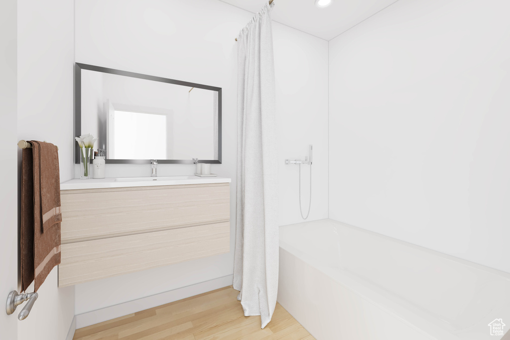 Bathroom featuring vanity, shower / bath combination with curtain, and hardwood / wood-style flooring
