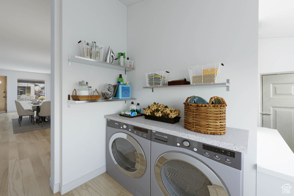 Washroom featuring washer and dryer and light hardwood / wood-style flooring