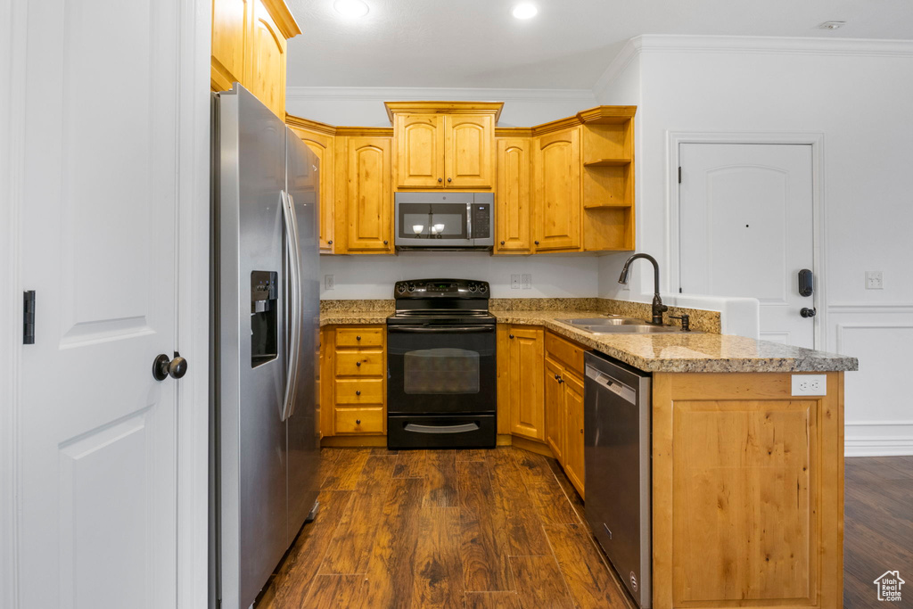 Kitchen with light stone countertops, sink, dark hardwood / wood-style flooring, crown molding, and appliances with stainless steel finishes