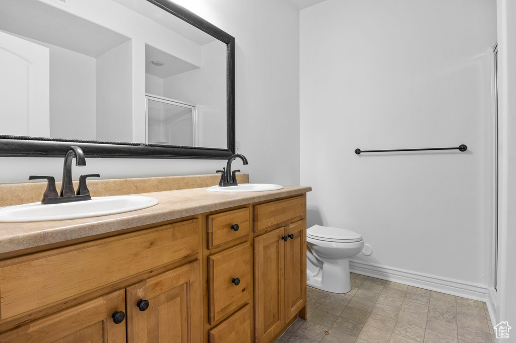 Bathroom featuring vanity, toilet, and walk in shower