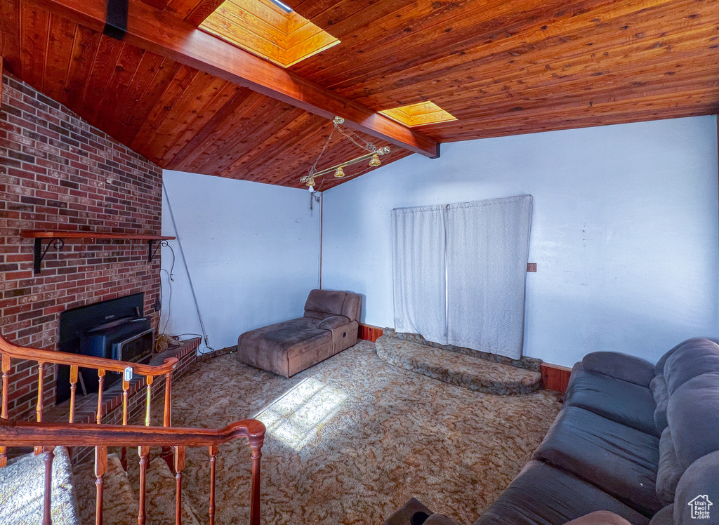 Carpeted living room featuring a wood stove and lofted ceiling with skylight