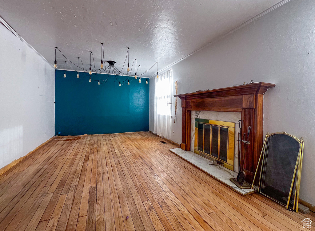 Unfurnished living room with a tile fireplace and wood-type flooring