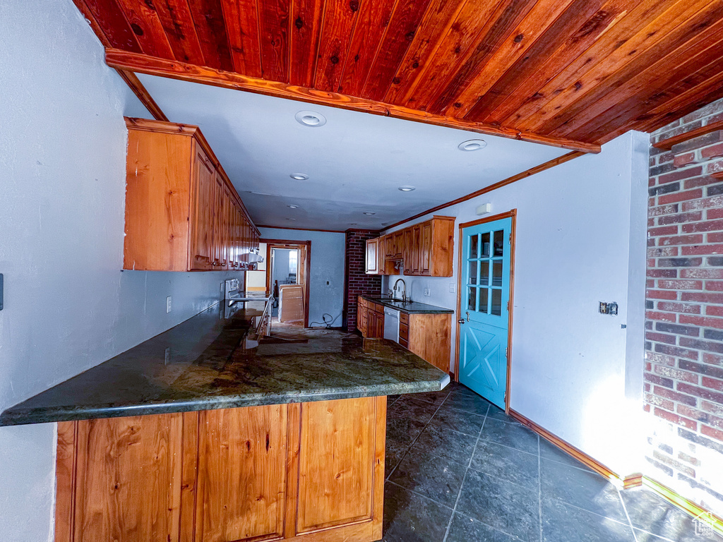 Kitchen with kitchen peninsula, dishwasher, ornamental molding, and sink