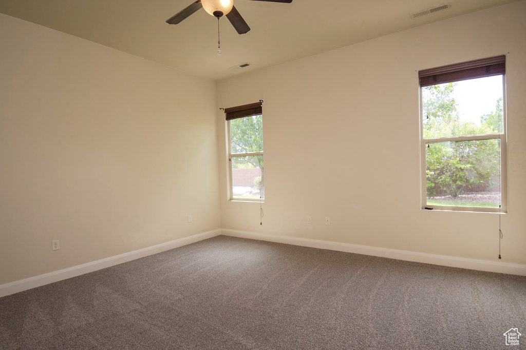 Carpeted empty room with ceiling fan