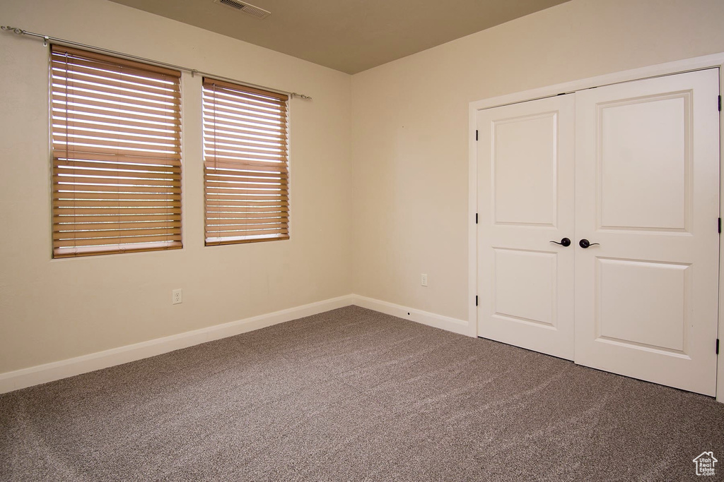 Unfurnished bedroom with carpet and a closet