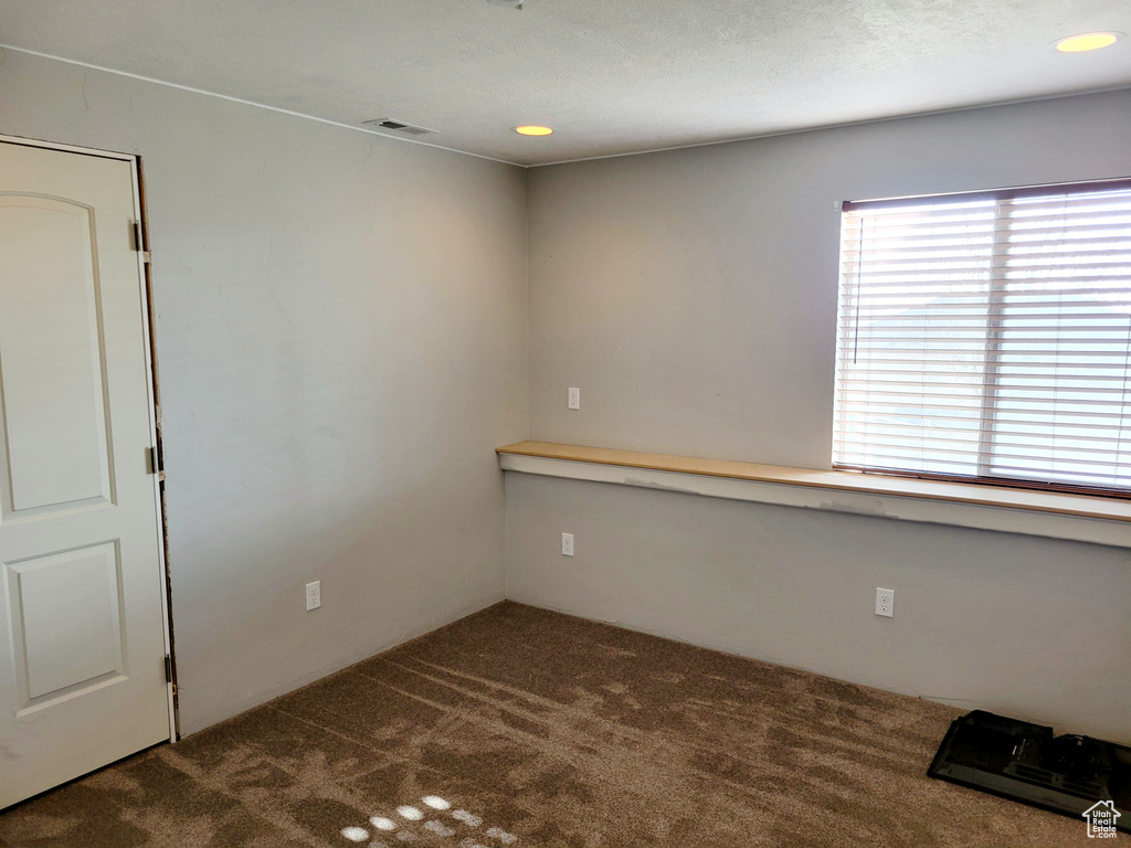 Spare room with dark colored carpet