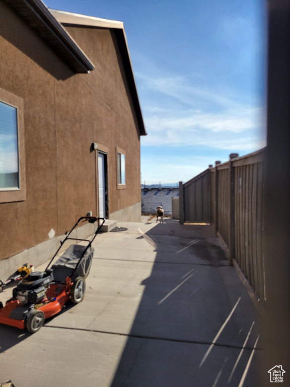 View of side of home with a water view and a patio