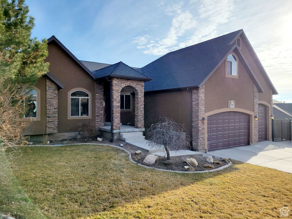 French country style house featuring a front yard and a garage