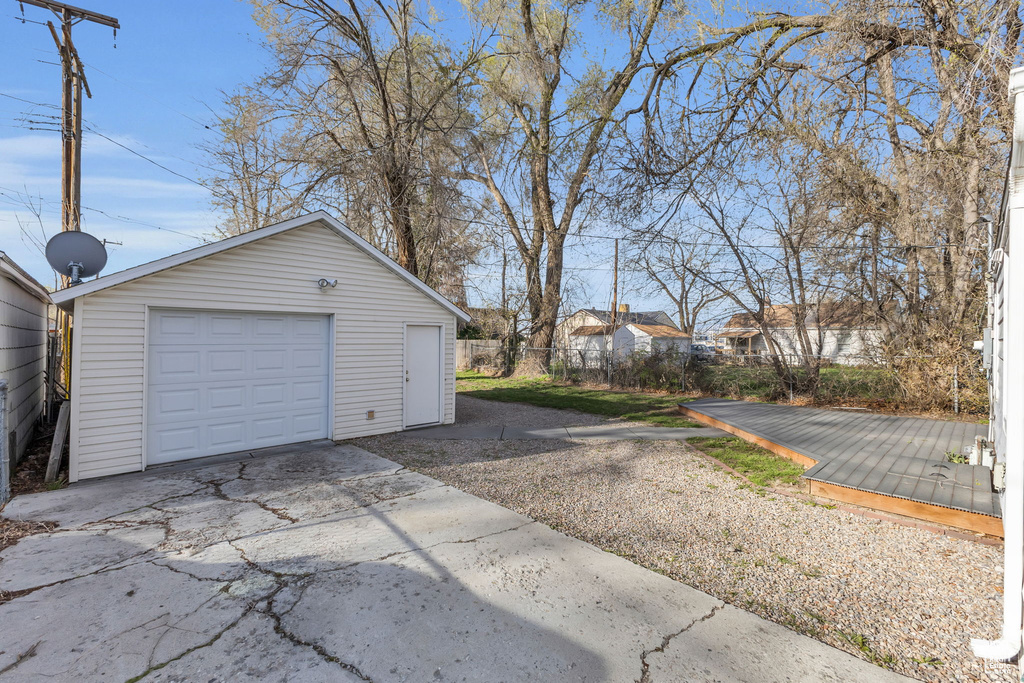 Detached garage featuring fence and concrete driveway