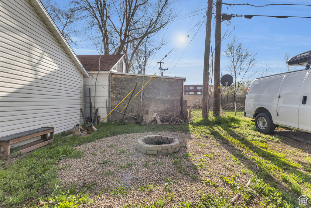 View of yard with fence and an outdoor fire pit