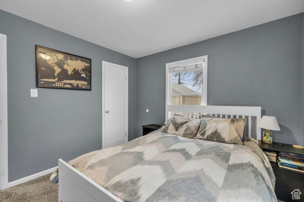 Bedroom featuring carpet flooring and a textured ceiling