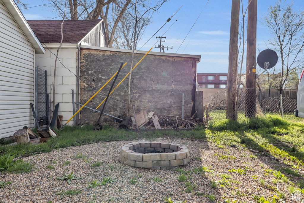 View of yard with fence and an outdoor fire pit