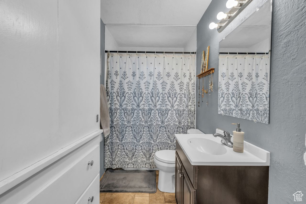 Bathroom with a shower with curtain, vanity, and toilet