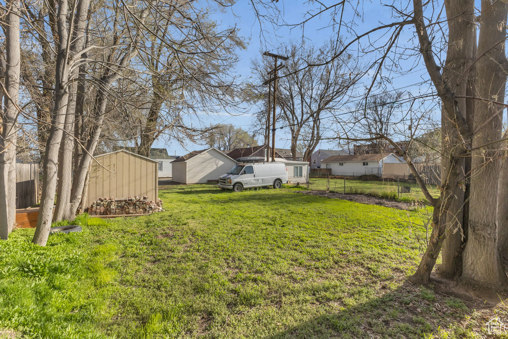 View of yard featuring an outbuilding, fence, and a storage unit