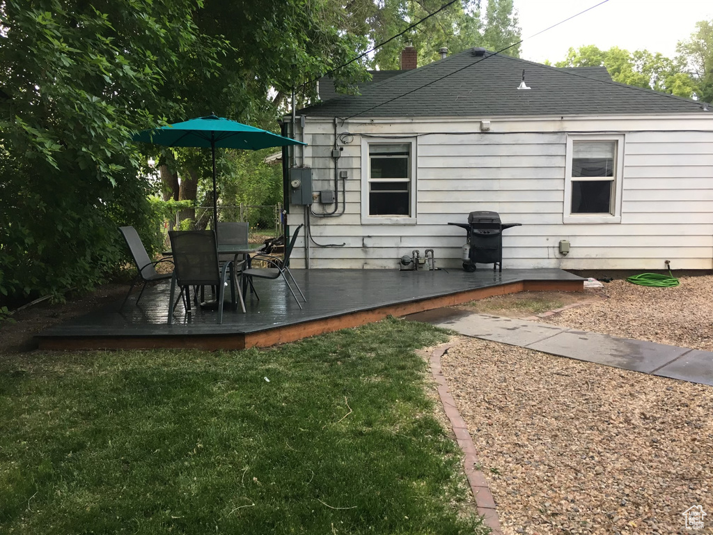 Rear view of property featuring a yard and a deck
