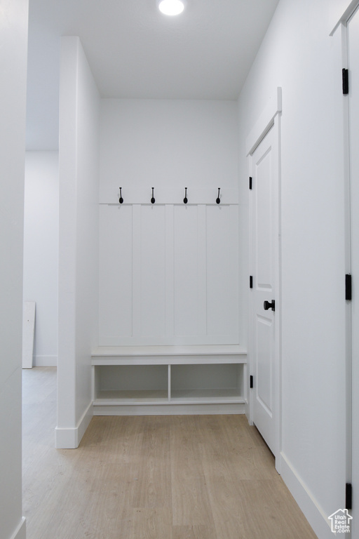 Mudroom with light wood finished floors and baseboards