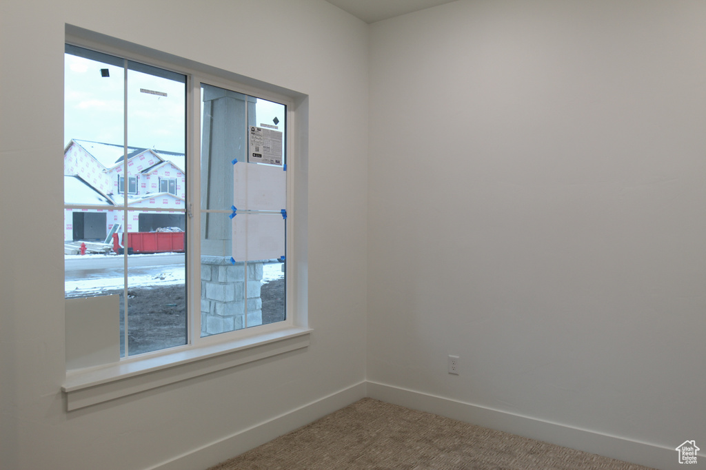 Carpeted empty room with baseboards