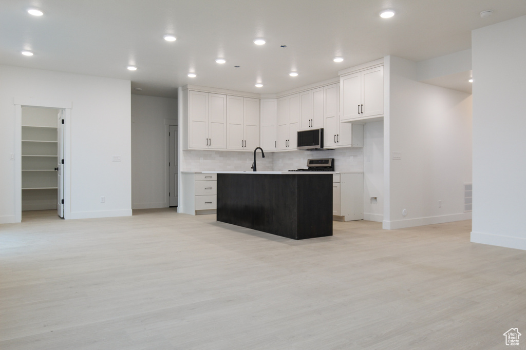 Kitchen featuring appliances with stainless steel finishes, baseboards, light wood-type flooring, and recessed lighting