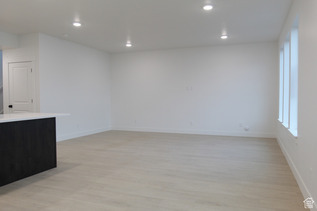Empty room featuring light wood-style floors, recessed lighting, and baseboards