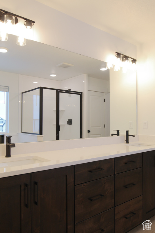 Full bathroom featuring double vanity and a stall shower