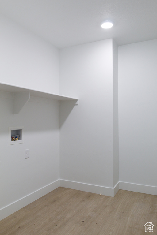 Laundry area featuring washer hookup, baseboards, and light wood-style floors