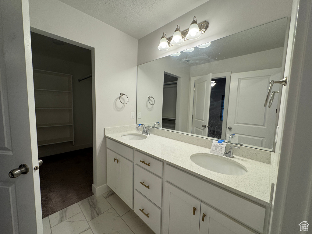 Bathroom with a textured ceiling and vanity