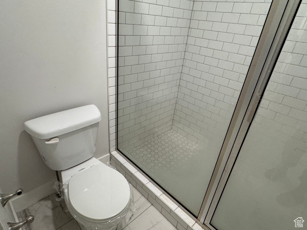 Bathroom with toilet and a shower with shower door