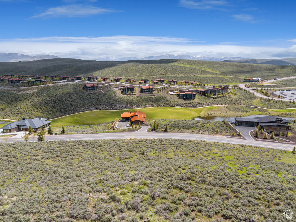 Aerial perspective of suburban area with a mountainous background and a golf club