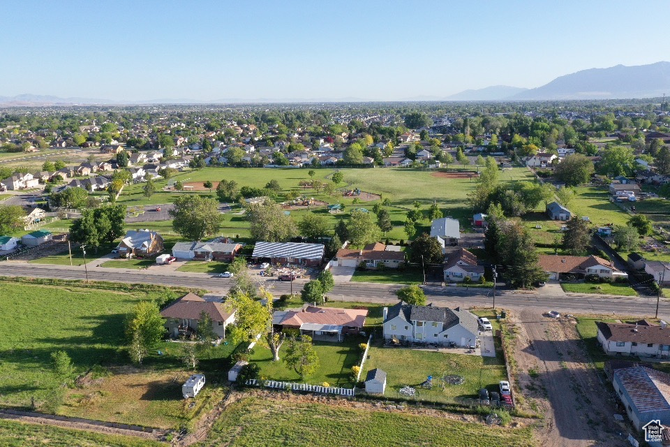 Aerial overview of property\'s location featuring nearby suburban area and a mountainous background
