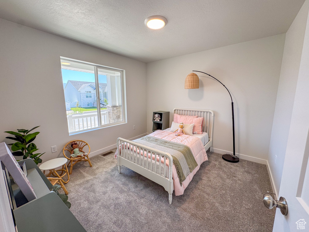 Bedroom featuring carpet floors and a textured ceiling
