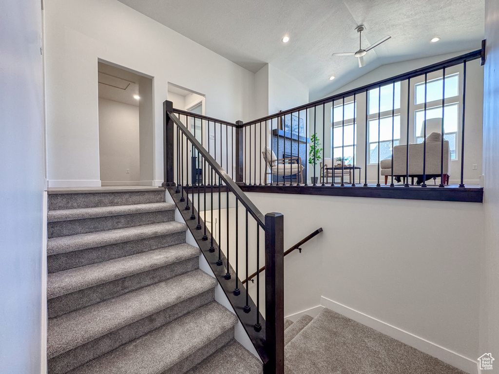 Stairs with lofted ceiling, carpet flooring, ceiling fan, and recessed lighting