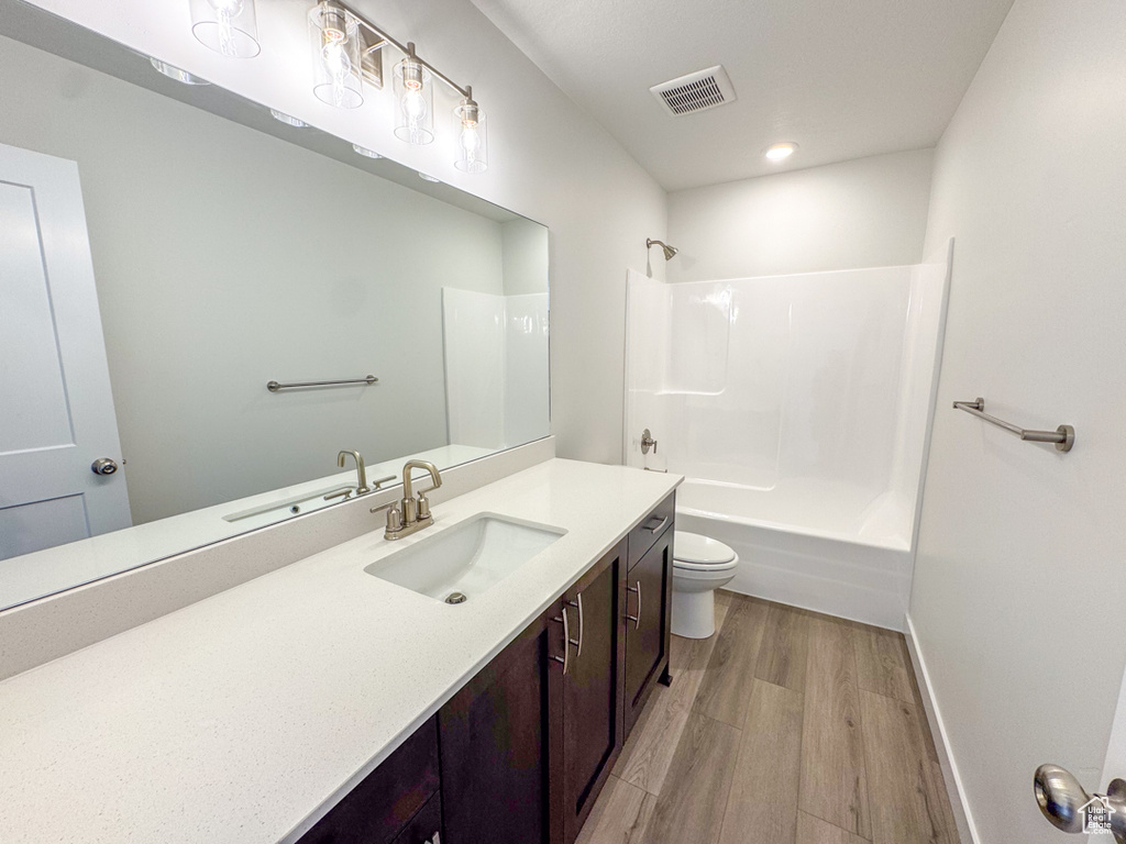 Bathroom featuring vanity, wood finished floors, and tub / shower combination