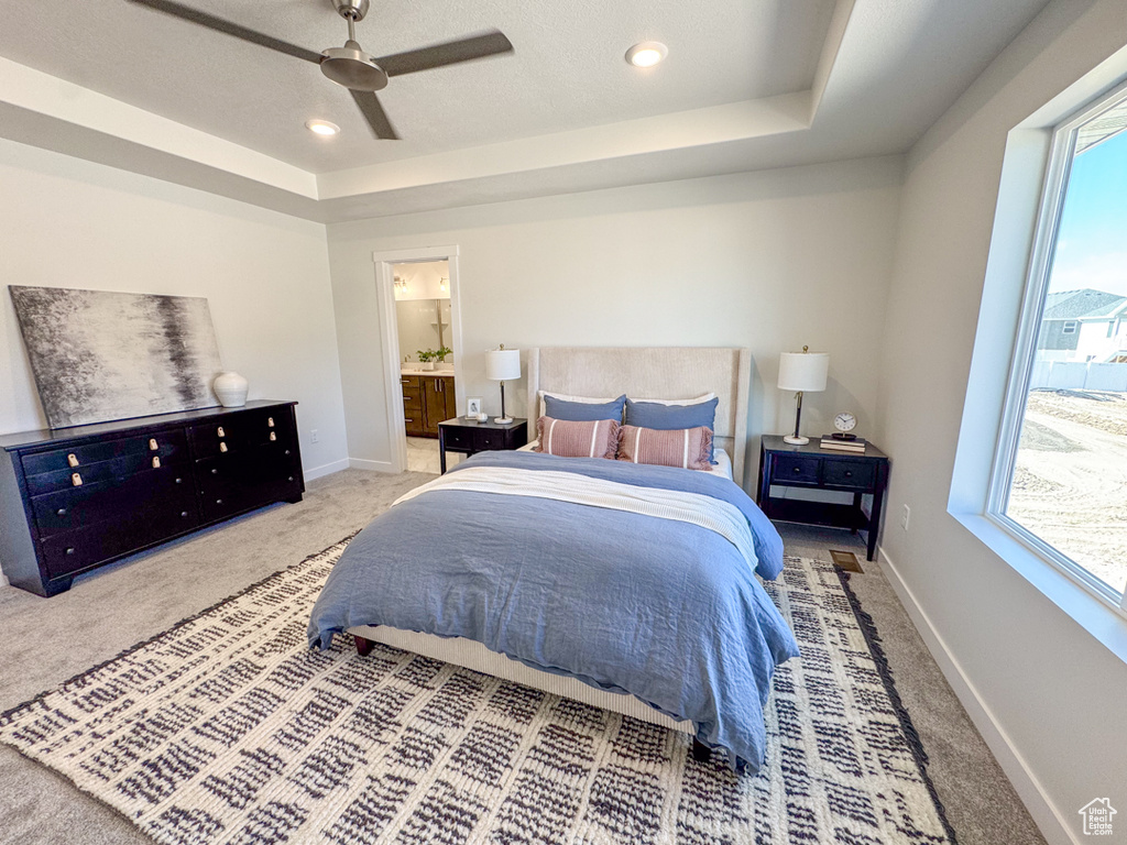 Bedroom featuring a raised ceiling, carpet, a ceiling fan, connected bathroom, and recessed lighting
