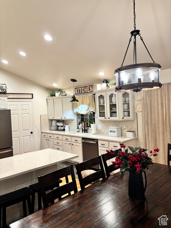 Dining space with dark hardwood / wood-style flooring and lofted ceiling