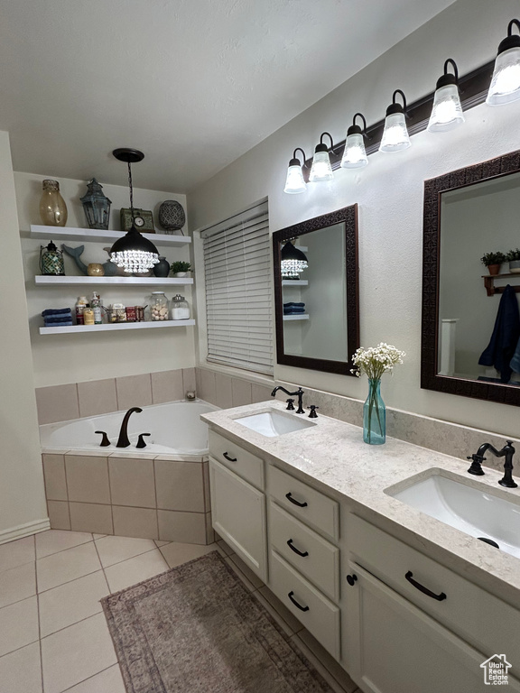 Bathroom featuring tile patterned floors, vanity, and tiled bath