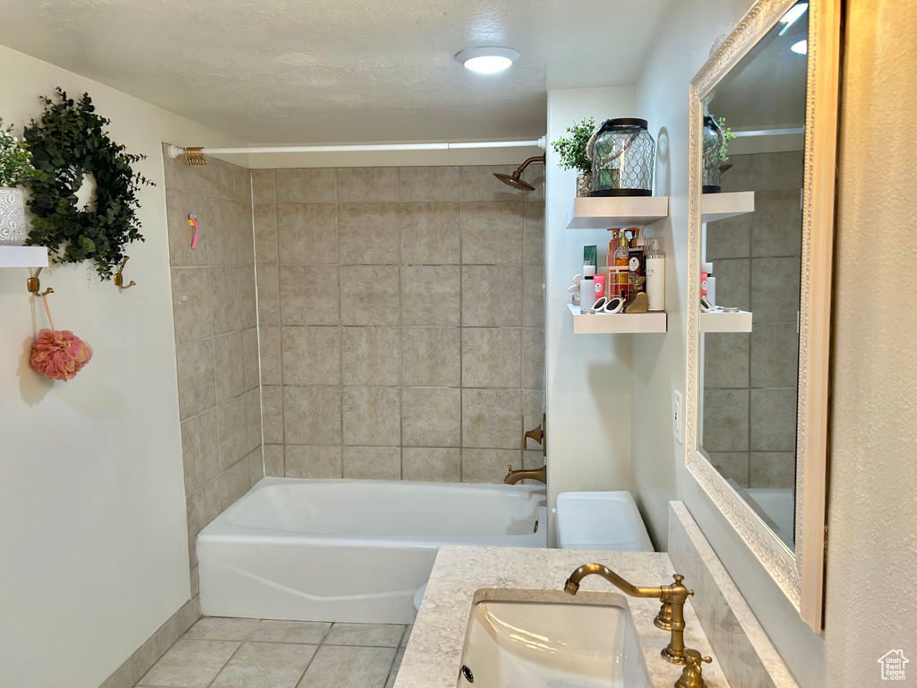 Full bathroom with tile patterned flooring, tiled shower / bath combo, toilet, and vanity